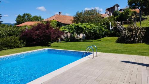 a swimming pool in a yard next to a house at Casa do Cerrado in Agunchos