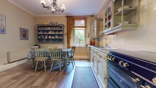 a kitchen with a table and chairs and a sink at Elgin Tower apartment in Minehead