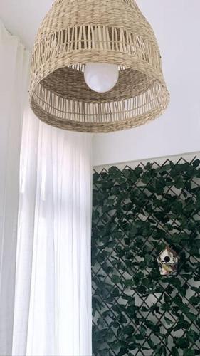 a wicker chandelier hanging from a ceiling in a bathroom at Apt 20 min from downtown train in Amadora