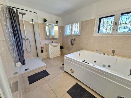 baño blanco grande con bañera y ducha en Villa Marseille dans les hauteurs en Marsella