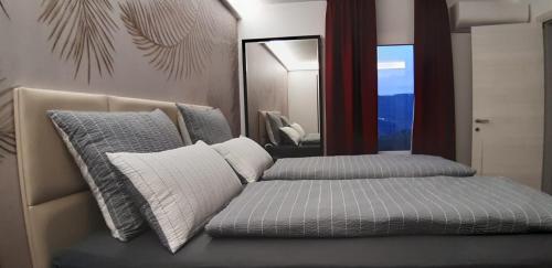 a bedroom with two beds and a mirror at Vinomare Guesthouse in Fosdinovo