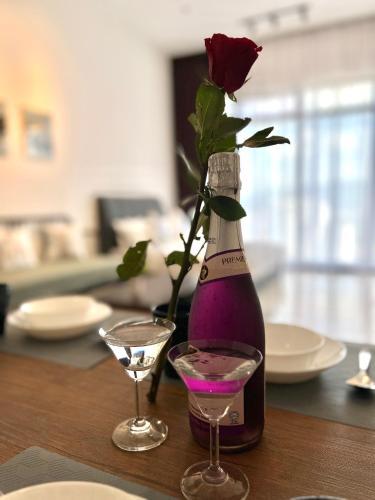 a bottle of wine with a rose and a glass at Georgetown#Amazing SkyPool#Modern & Elegant Suite# in George Town
