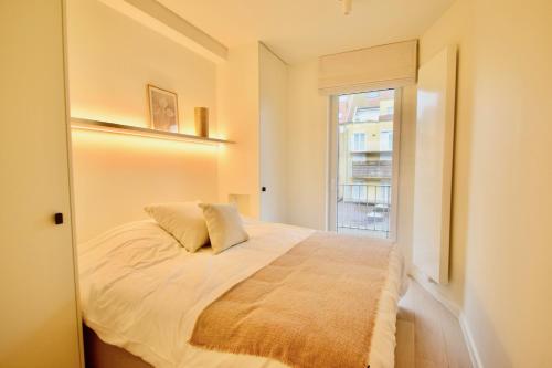 a bedroom with a bed and a window at Appartement 3CH entièrement rénové Knokke - Centre in Knokke-Heist