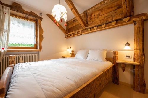 een slaapkamer met een groot wit bed in een kamer bij Cesa Anna in Campitello di Fassa