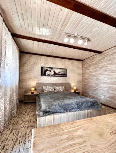 a bedroom with a large bed and two tables at Edelweiss House in Svityazʼ