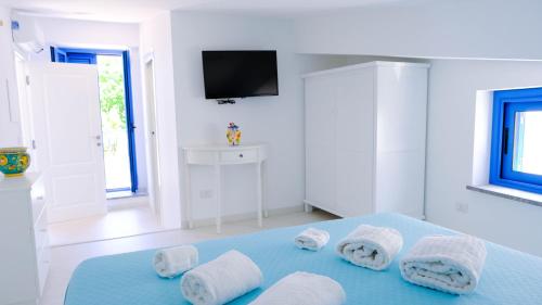 Habitación blanca con toallas en una cama azul en Villa dei Due Ulivi en Capo dʼOrlando