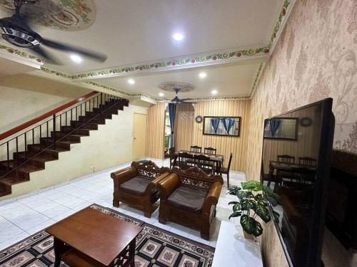 uma sala de estar com sofás e uma mesa e escadas em Homestay Jati by NazTi em Seremban