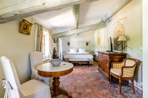 a bedroom with a bed and a table and chairs at La Bastide des Saveurs in La Cadiere d'Azur