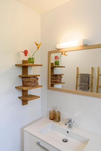 a bathroom with a white sink and a mirror at MadouBamboo in Ducos
