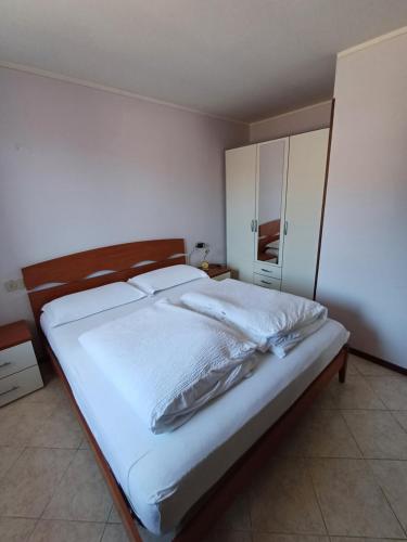 a bedroom with a large bed with white sheets at CASA SAN MICHELE in Bovegno