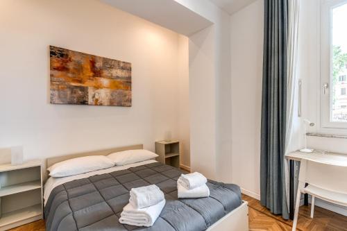 Schlafzimmer mit einem Bett, einem Schreibtisch und einem Fenster in der Unterkunft V E N E R E Apartments in Rom
