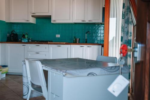 a kitchen with white cabinets and a table with chairs at Magnolia Rooms in Civitavecchia