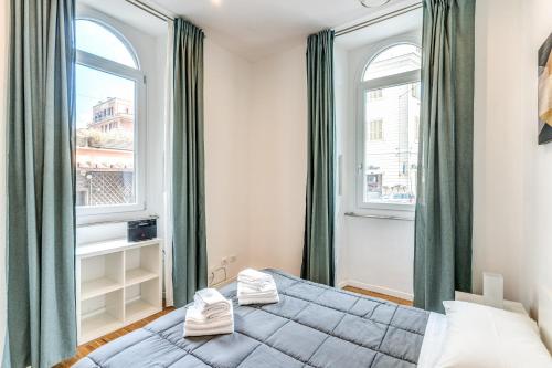 ein Schlafzimmer mit einem Bett und zwei Fenstern in der Unterkunft V E N E R E Apartments in Rom