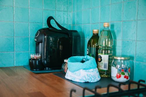 a counter with a suitcase and a bottle of alcohol at Magnolia Rooms in Civitavecchia
