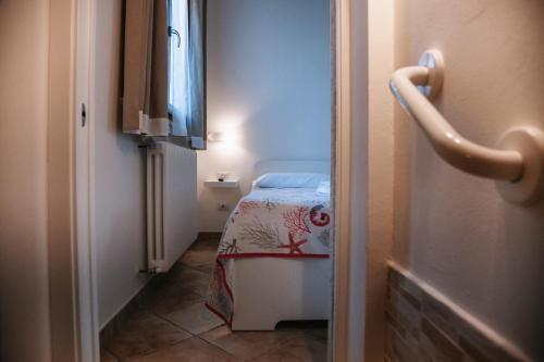 a small bedroom with a bed in a small room at Magnolia Rooms in Civitavecchia