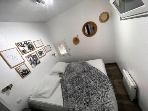 une chambre avec un lit avec une couverture dessus dans l'établissement Villa Village Naturiste Karess, au Cap d'Agde