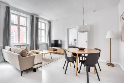 a living room with a table and chairs and a couch at Cozy Flats in Heart of Copenhagen Near Strøget & Højbro Plads in Copenhagen