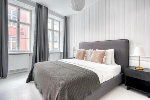 a white bedroom with a large bed with pillows at Cozy Apartments in Heart of Copenhagen Near Strøget & Højbro Plads in Copenhagen