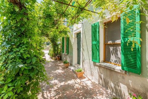an alley with green shutters on a building at La Bastide des Saveurs in La Cadiere d'Azur