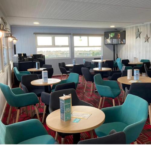 a waiting room with tables and green chairs at Caravan on Mersea Island Away Resorts Quiet Location in East Mersea