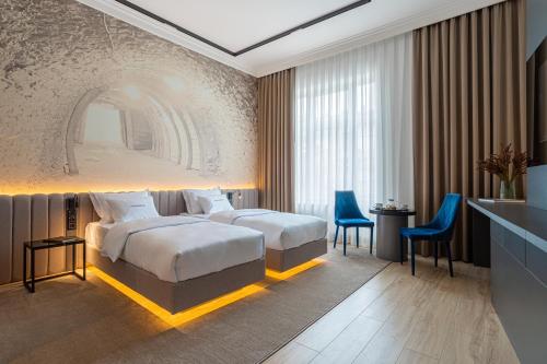Pokój hotelowy z dużym łóżkiem i niebieskimi krzesłami w obiekcie Villa Boutique Hotel w mieście Mukaczewo