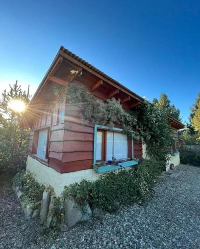 une petite maison avec du lierre sur son côté dans l'établissement CABAÑA EN BARILOCHE, à San Carlos de Bariloche