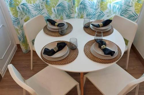 a white table with hats and plates on it at Apartamento Centroplaya in Bueu