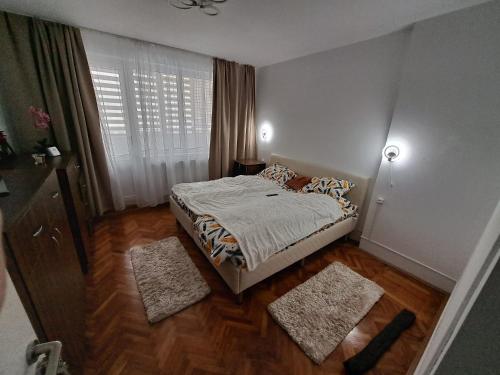 a small bedroom with a bed and a window at Apartament 2 camere in Zalău