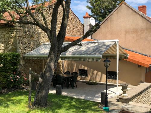 a patio with a table and chairs in front of a house at Gîte de la Croix Mandet 