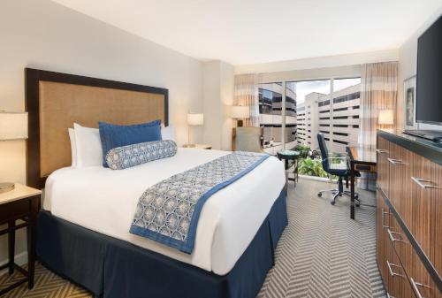 a hotel room with a large bed and a television at The Westshore Grand, A Tribute Portfolio Hotel, Tampa in Tampa