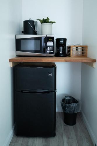 a microwave sitting on a shelf above a refrigerator at The Carriage House at Strasburg in Strasburg