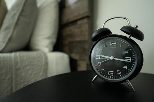 a black alarm clock sitting on top of a table at The Carriage House at Strasburg in Strasburg