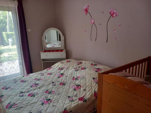 a bedroom with a bed with flowers on the wall at Kiss Apartman in Balatonberény
