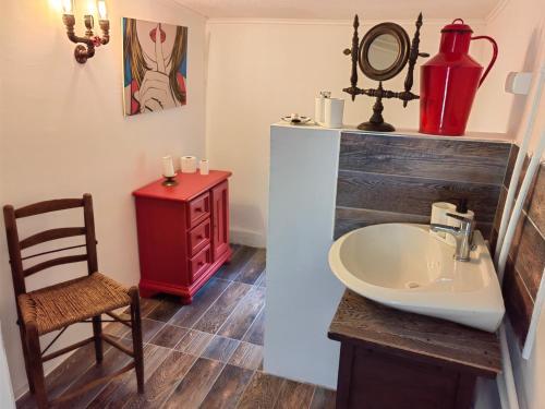 a bathroom with a sink and a chair at Haus Lilli 