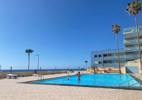 uma pessoa de pé em uma piscina ao lado de um edifício em Casa Elena em Candelaria