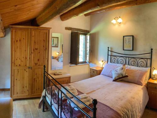 AmandolaにあるIl Nascondiglio - The Hideawayの木製の天井の客室で、ベッドルーム1室(大型ベッド1台付)