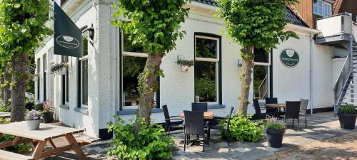 a group of tables and chairs in front of a building at Herberg Boswijck, B&B in Wijckel