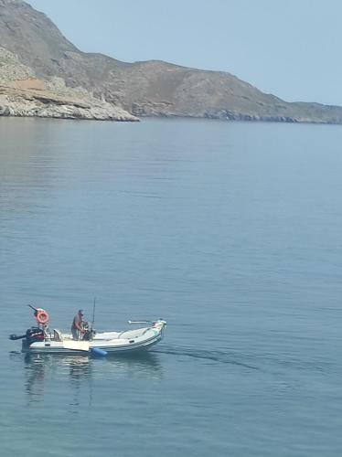 two people in a boat on a body of water at Coastline of Paradise in Paránimfoi