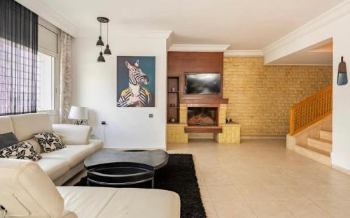 a living room with a couch and a fireplace at Luxueux et moderne duplex in Hay Riad in Rabat