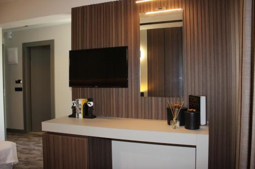 a bathroom with a counter with a tv on a wall at Monalisa Hotels KUŞADASI in Kusadası