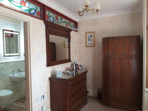 uma casa de banho com um lavatório, um WC e um espelho. em St David's Guesthouse em Haverfordwest