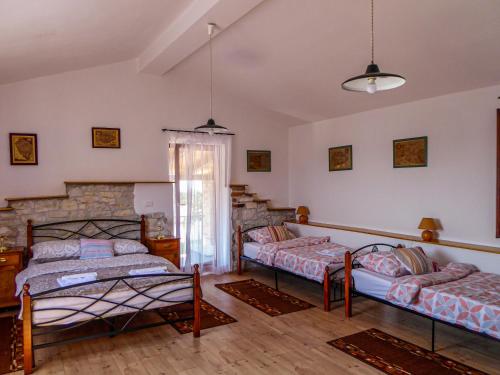 1 dormitorio con 2 camas y pared de piedra en Casa istriana nona Pina, en Kaštelir