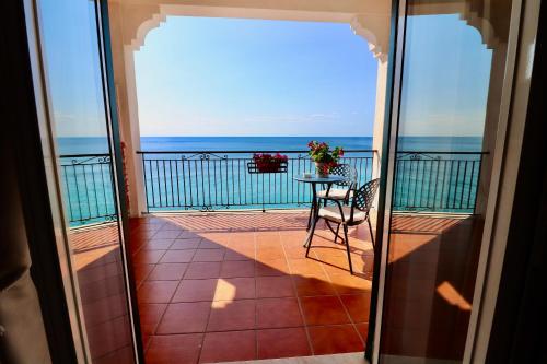 a balcony with a table and a view of the ocean at Park Hotel Silemi in Letojanni