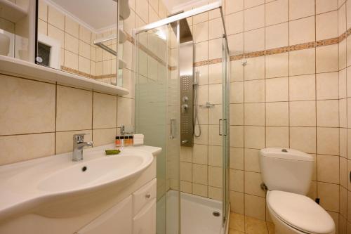 a bathroom with a toilet and a sink and a shower at Seaduced Beachfront Villa by CorfuEscapes in Glyfada