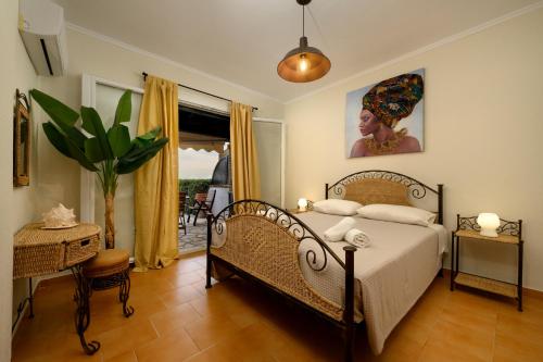 a bedroom with a bed and a potted plant at Seaduced Beachfront Villa by CorfuEscapes in Glyfada