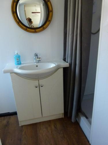 ein Bad mit einem Waschbecken und einem Wandspiegel in der Unterkunft Holly in Middlesbrough