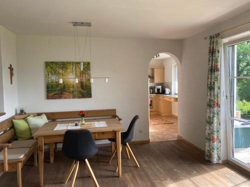 a living room with a dining room table and a kitchen at Garten Apartment Diwoky in Sankt Gilgen