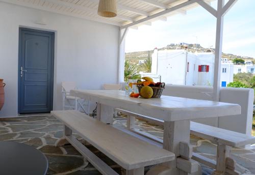 una mesa blanca y bancos en una habitación con ventana en Studio Ornos, en Ornos