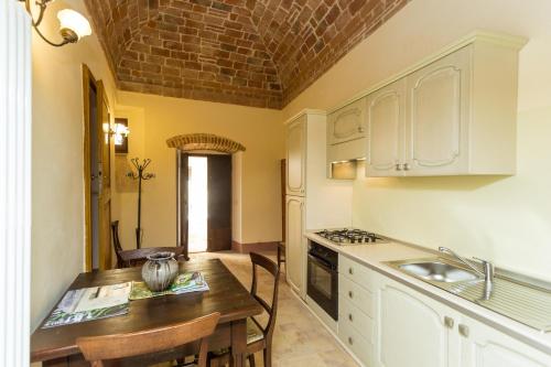 a kitchen with a table with chairs and a sink at Borgo Colognola - Dimora Storica in Cenerente