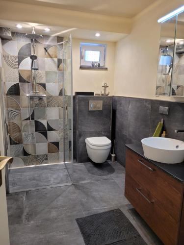 a bathroom with a toilet and a sink and a shower at Ferienwohnung Riesling in Bobenheim am Berg